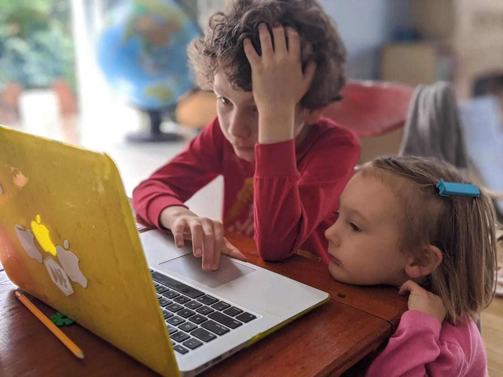 Two children studying on a laptop