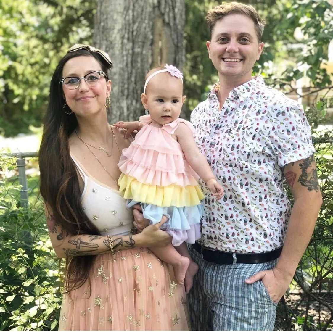A married couple holding their infant daughter.