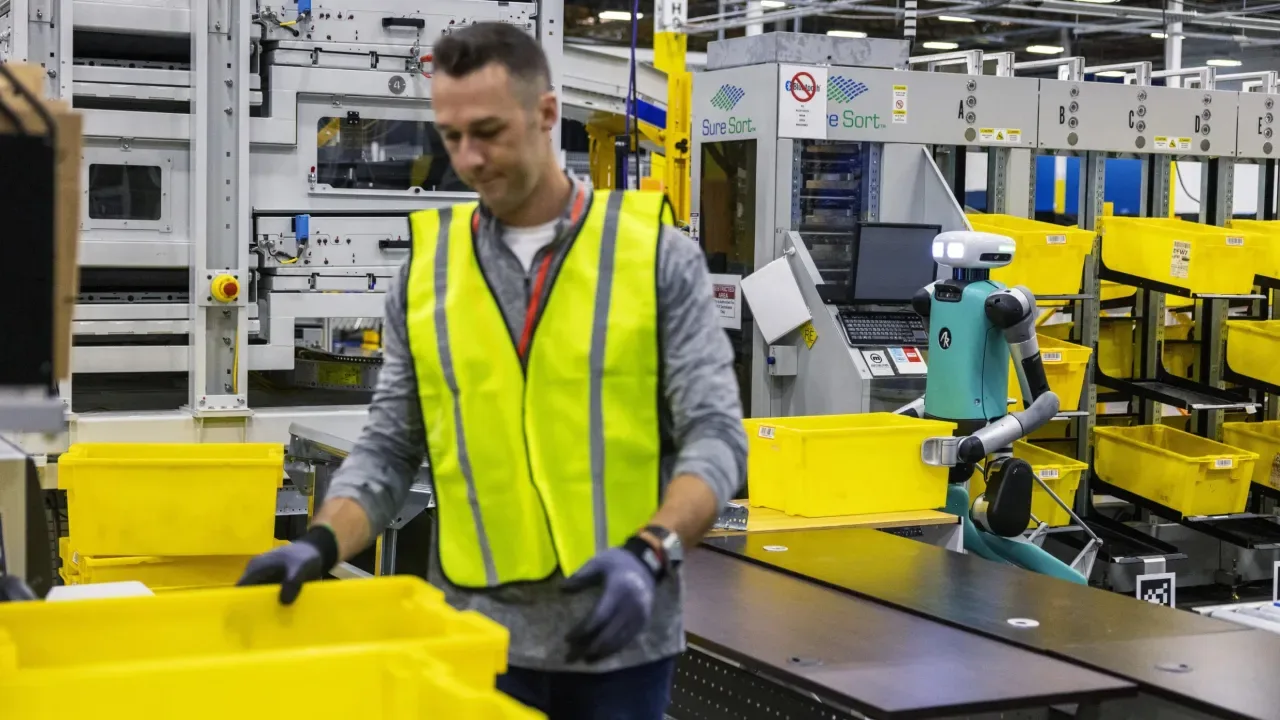An Amazon warehouse robot working alongside workers, showcasing the versatility of AI agent examples.